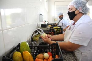 Funcionária do Banco de Alimentos de Divinópolis lava e prepara alimentos pra doação