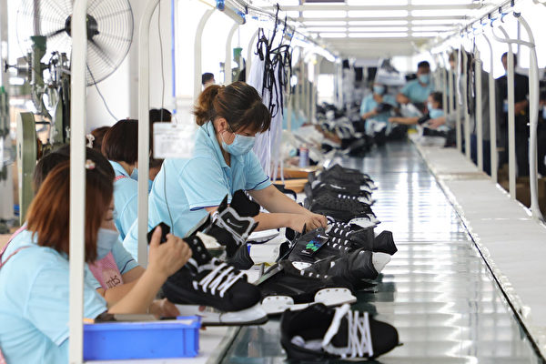 Chineses trabalham em fábrica de calçados